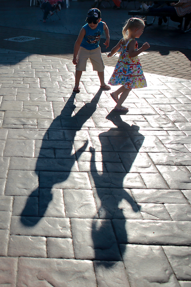 Conner and Lily Schulthess watch their shadows as they dance to the Troy Fair Band at the Loggerodeo Street Dance on July 3, 2013 in Sedro-Woolley, Wash.  Brooke Warren / Skagit Valley Herald